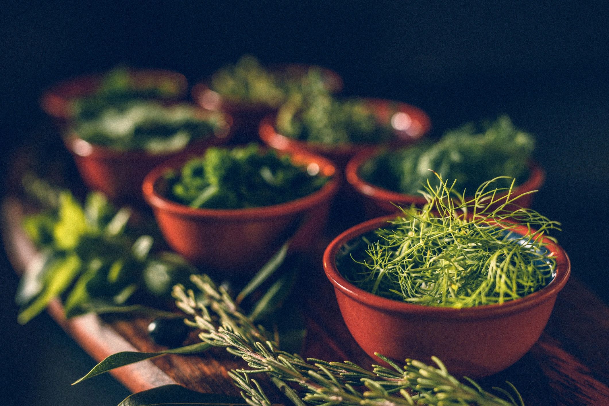 Assorted fresh green herbs on a rustic wooden board