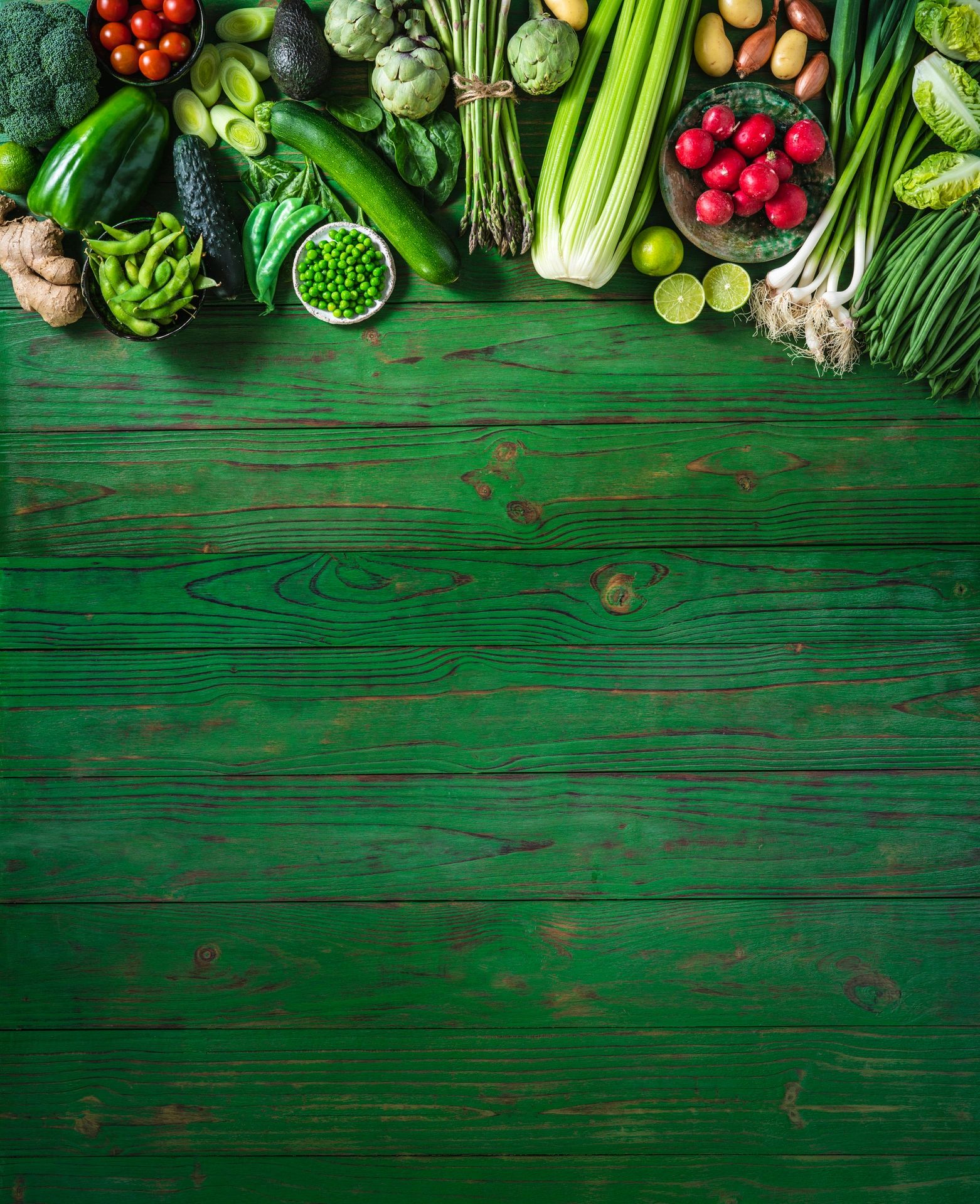 Fresh vegetables on a green wooden table with copy space