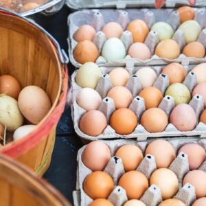 Farm Fresh Eggs — dozen brown eggs in a carton on a rustic farm table