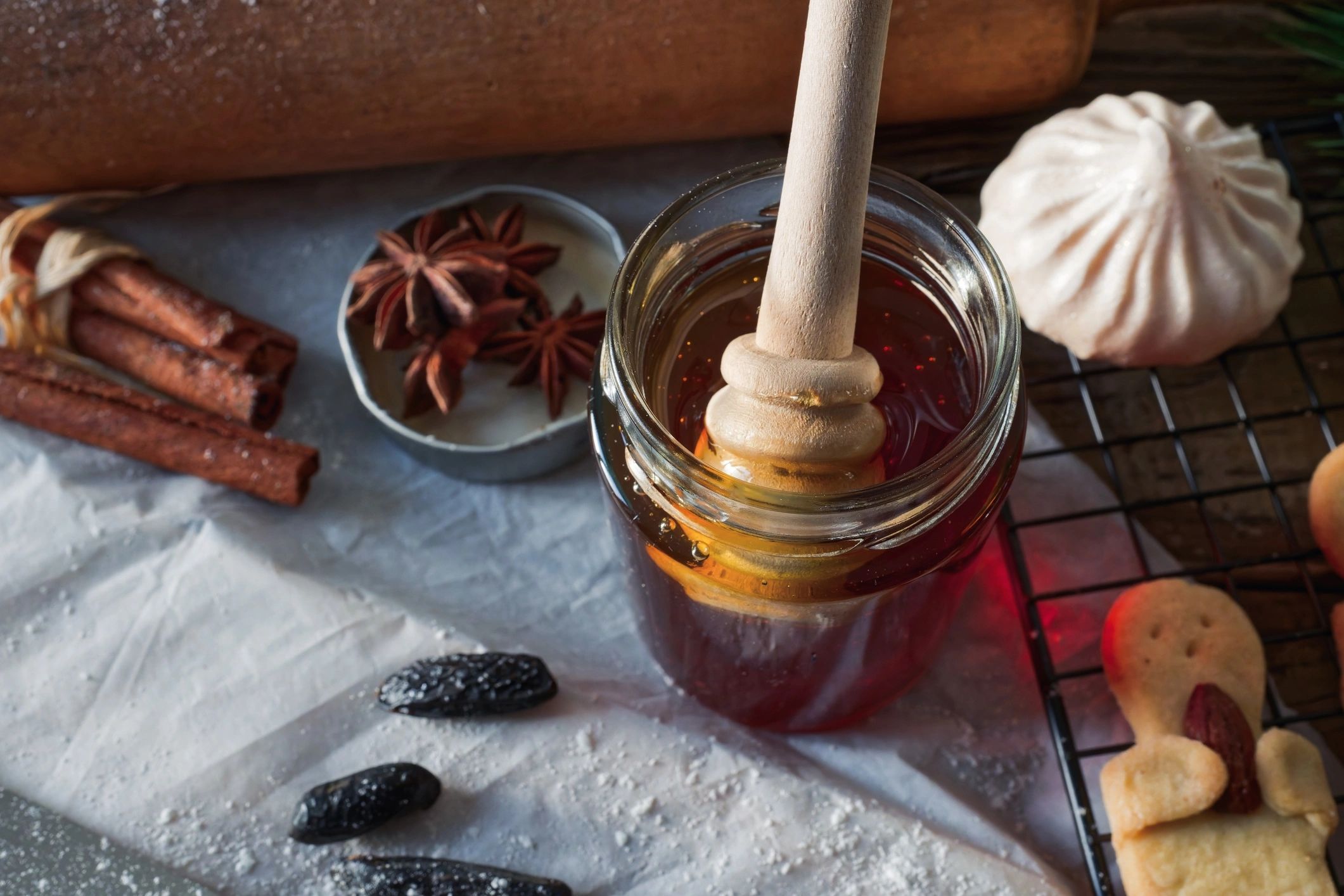 Glass honey jar with wooden dipper on a rustic table